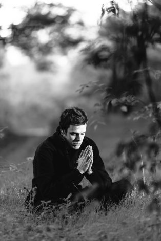 grayscale-photography-of-man-sitting-on-grass-field-156151